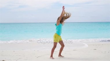 Aktif küçük kız plajda çok eğleniyorum. Sportif çocuk deniz kıyısı direksiyonda yapar. Ağır çekim