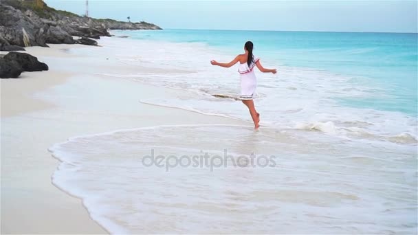 Молодая красивая женщина на белом тропическом пляже. Девушка, идущая вдоль моря. Медленное движение — стоковое видео