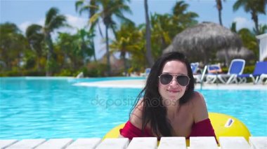 Mutlu kız havuzda eğleniyor. Güzel kadın lüks otelde açık yüzme havuzunda. Ağır çekim