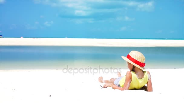 Zadní pohled na malé dítě v klobouku na pláži během karibské tropické dovolené. Zpomalený pohyb. — Stock video