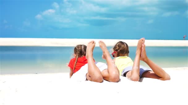 Malé dívky baví na tropické pláži leží vedle sebe na břehu moře. Zpomalený pohyb — Stock video