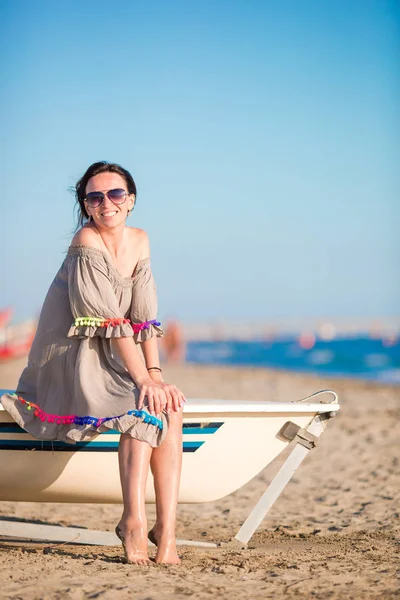Jovem mulher bonita na praia durante as férias de verão. Menina sentada no barco na praia europeia — Fotografia de Stock