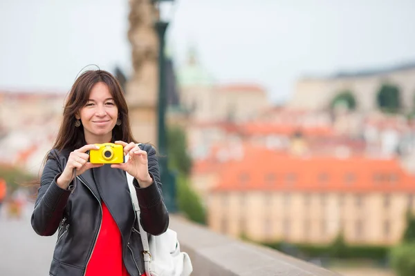 Счастливая молодая женщина в европейском городе на знаменитом мосту. Кавказская туристка сфотографировалась на камеру в Праге — стоковое фото