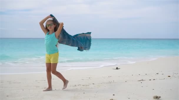 Pequena menina adorável se divertindo correndo com pareo na praia tropical — Vídeo de Stock