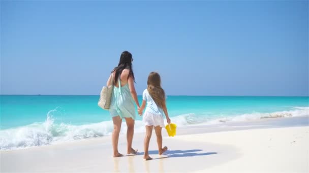 Маленькая симпатичная девочка и молодая мама на пляже — стоковое видео