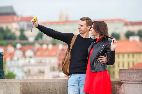 Pareja joven viajando de vacaciones en Europa sonriendo feliz. Caucásico familia haciendo selfie en popular karlov la mayoría — Foto de Stock