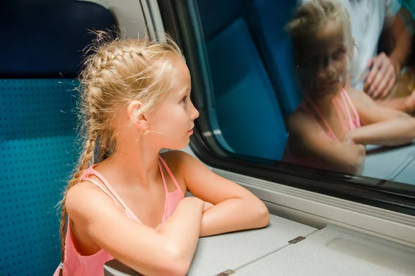 Adorable niño mirando por la ventana del tren afuera, mientras se mueve . — Foto de Stock