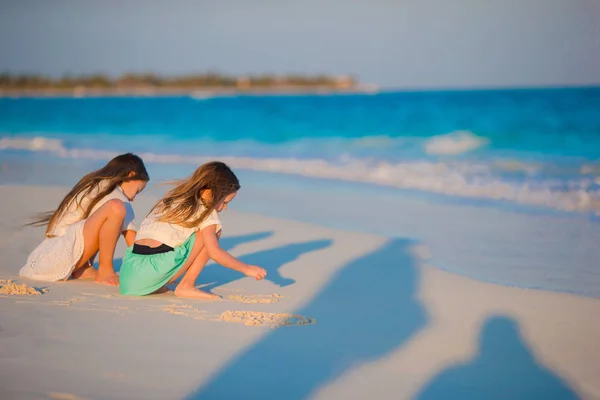 Adorable little kids having fun together drawing on the sand on white beach — Stock Photo, Image