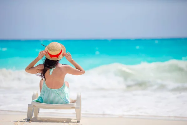 Back view of girl in hat on a tropical beach looking on the beautiful sea — Stock Photo, Image