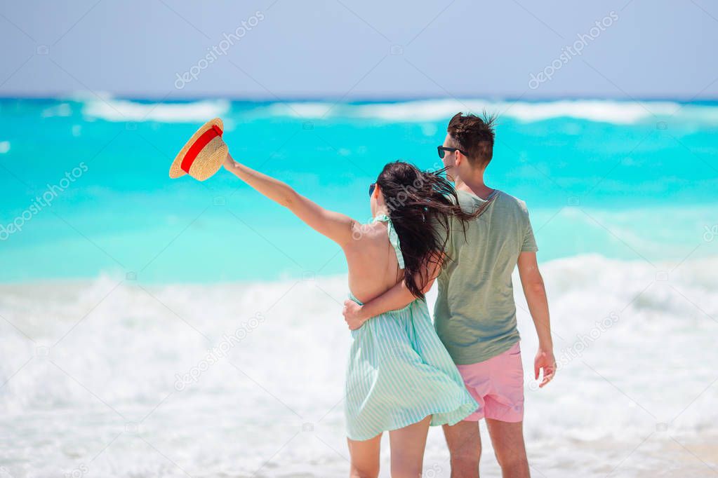 Young couple on white beach. Family vacation