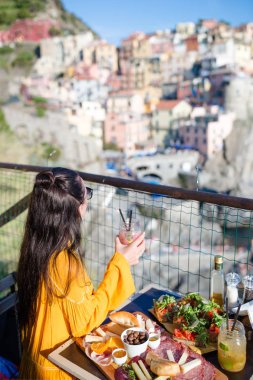 Cinque Terre 'de harika manzarası olan açık kafede kahvaltıda güzel bir kadın.