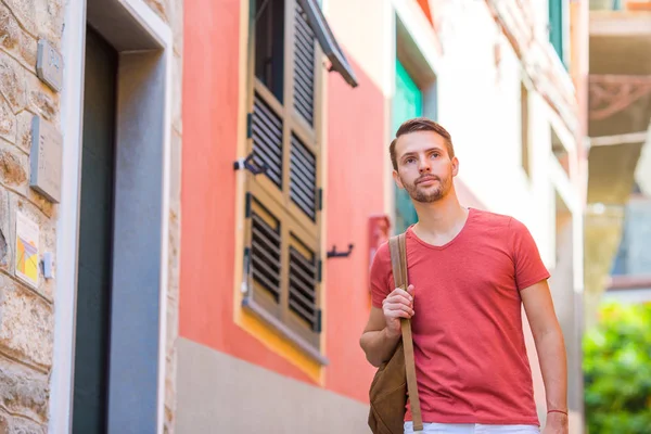 Happy man tourist during holidays in Cinque Terre. Young caucasian guy walking at the old street in Manarola — Stock Photo, Image