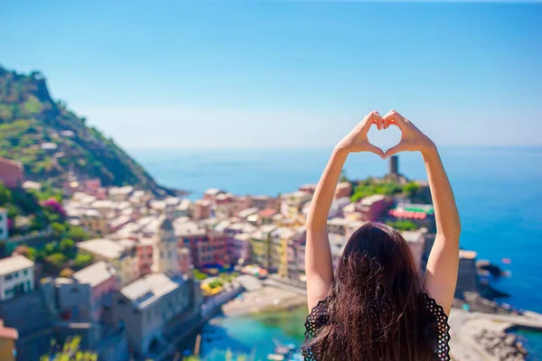 Gelukkig meisje maken met handen hart vorm op de oude kuststad achtergrond van Vernazza, Cinque Terre National Park. Europese vakantie. — Stockfoto