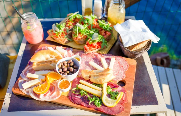 Gustoso cibo italiano. Bruschette fresche, formaggi e carne in tavola in un caffè all'aperto con vista mozzafiato a Manarola — Foto Stock