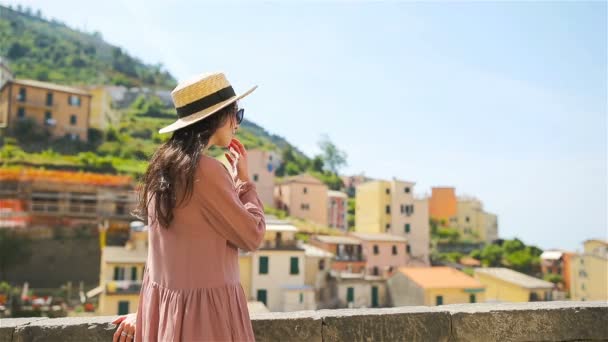 Junge Frau mit tollem Blick auf das alte Dorf riomaggiore, cinque terre, ligurien, italien. Italienischer Urlaub. — Stockvideo