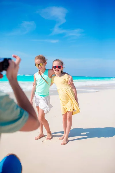 Ojciec zrobić zdjęcie jego małych dziewczynek na białym tle tropikalnej plaży na karaibskiej wyspie mają dużo zabawy — Zdjęcie stockowe