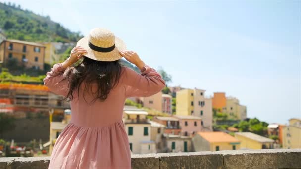 Mujer joven con hermosa vista en el antiguo pueblo Riomaggiore, Cinque Terre, Liguria, Italia. Vacaciones italianas europeas . — Vídeos de Stock