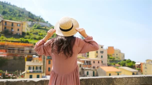 Mujer joven con una gran vista en el antiguo pueblo Riomaggiore, Cinque Terre, Liguria, Italia. Vacaciones italianas europeas . — Vídeos de Stock