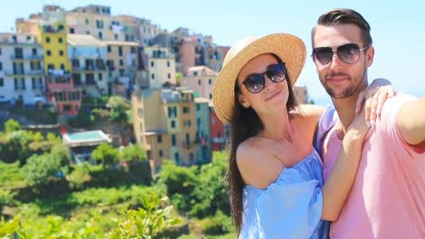 Familia feliz tomando selfie con vista a la antigua ciudad costera de fondo de Corniglia, Parque Nacional Cinque Terre, Liguria, Italia, Europa — Vídeo de stock