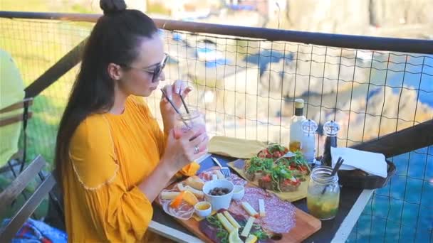 Mooie vrouw op Ontbijt op terras met geweldig uitzicht op Manarola in Cinque Terre — Stockvideo