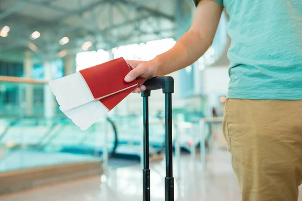 Primer plano de pasaportes y tarjeta de embarque en manos masculinas en el aeropuerto —  Fotos de Stock