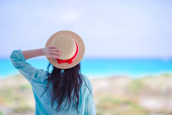 Junge Frau mit Hut am tropischen Strand mit Blick auf das schöne Meer — Stockfoto