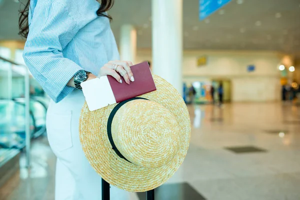 Primer plano de pasaportes y tarjeta de embarque en manos femeninas en el aeropuerto —  Fotos de Stock