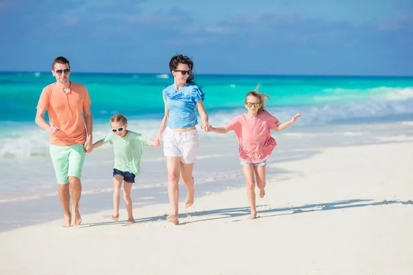 Felice famiglia di quattro persone su una spiaggia tropicale godere di vacanze estive — Foto Stock