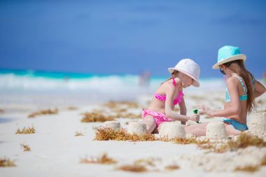 Çok güzel küçük çocuklar beyaz sahilde kum ile oynamak