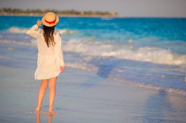 Günbatımı, tropikal deniz kıyısı üzerinde genç güzel kadın. Mutlu kız sahilde akşam elbiseli