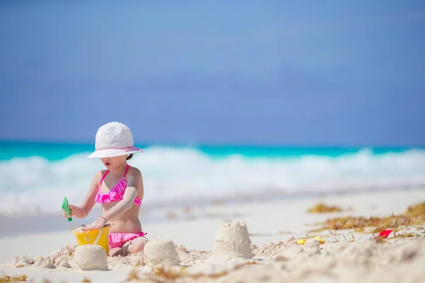 Imádnivaló kislány játszik strand játékok fehér trópusi strand — Stock Fotó