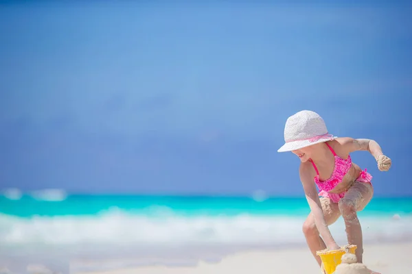 Adorabile bambina che gioca con i giocattoli della spiaggia sulla spiaggia tropiale bianca — Foto Stock