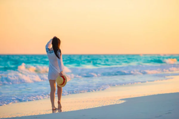 Νεαρή όμορφη γυναίκα στην τροπική παραλία στο ηλιοβασίλεμα. Ευτυχισμένος κορίτσι στο φόρεμα το βράδυ στην παραλία — Φωτογραφία Αρχείου