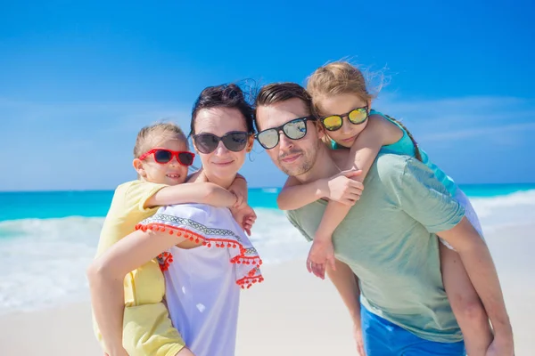 Família bonita feliz de quatro em uma praia tropical — Fotografia de Stock