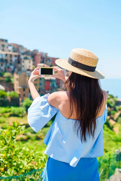 Mujer joven tomar una foto de hermosa vista en el antiguo pueblo de Cinque Terre, Liguria, Italia. Vacaciones italianas europeas . —  Fotos de Stock