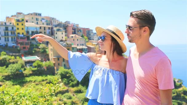 Casal feliz com vista para o fundo da antiga aldeia costeira de Corniglia, Cinque Terre parque nacional, Ligúria, Itália, Europa — Vídeo de Stock