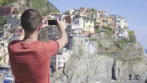 Joven tomar una foto de la hermosa vista en el antiguo pueblo de Cinque Terre, Liguria, Italia. Vacaciones italianas europeas . — Vídeos de Stock