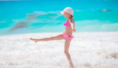 Kumsaldaki sevimli küçük kız sığ sularda çok eğleniyor.