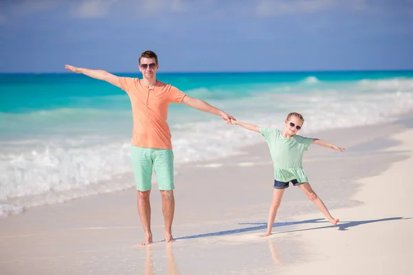 Niña y padre joven se divierten juntos durante las vacaciones en la playa — Foto de Stock