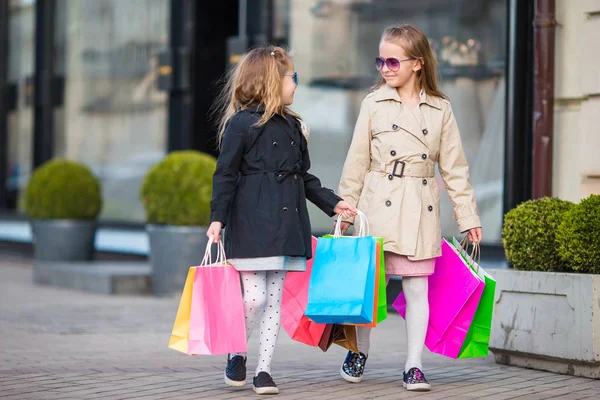 Чарівні маленькі дівчата з сумками, що ходять у місті на відкритому повітрі — стокове фото