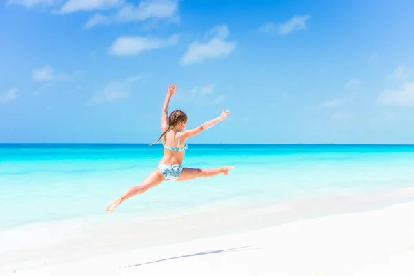 Chica activa en la playa divirtiéndose mucho en la orilla dando un salto —  Fotos de Stock