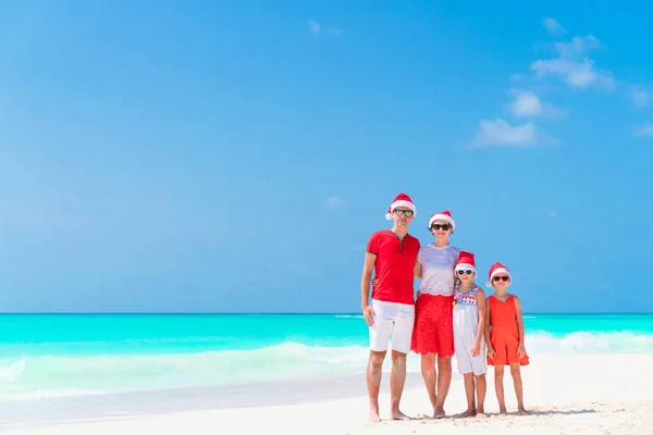 Glückliche Familie in Weihnachtsmützen im tropischen Weihnachtsurlaub — Stockfoto