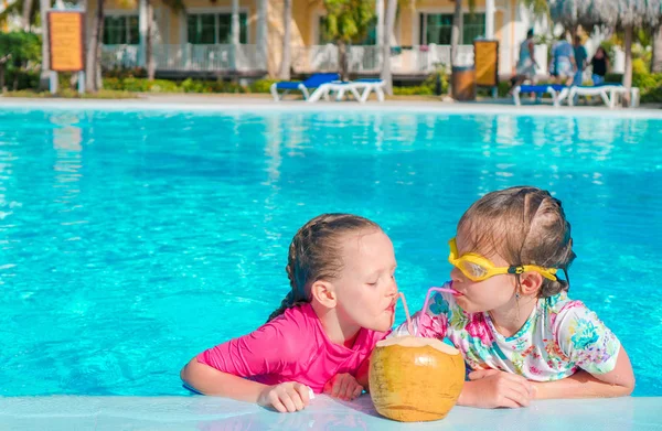 Kinderen in zwembad buiten drink kokosmelk — Stockfoto