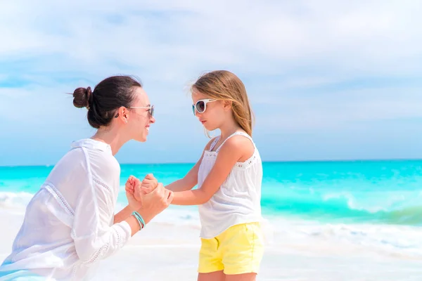 Piccola ragazza adorabile e giovane madre sulla spiaggia tropicale. Vacanza al mare in famiglia — Foto Stock