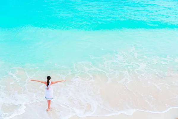 Młody turysta szczęśliwy dziewczyna na plaży, mając mnóstwo zabawy w płytkiej wodzie. Widok z góry młoda dziewczyna i piaszczystej plaży turkus czystą wodą. — Zdjęcie stockowe