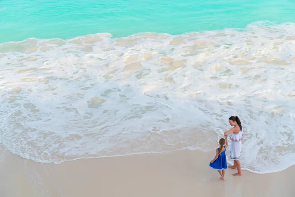 Piccola adorabile ragazza e giovane madre sulla spiaggia tropicale con vista turchese dall'alto — Foto Stock