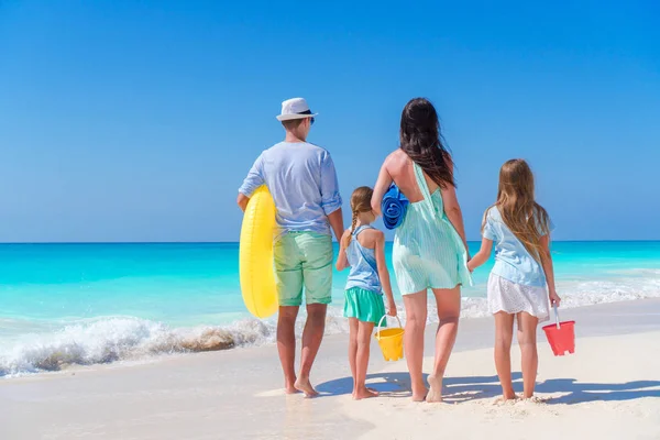 Familie reizen concept. Achteraanzicht van jonge gezin met twee kinderen aan de kust — Stockfoto