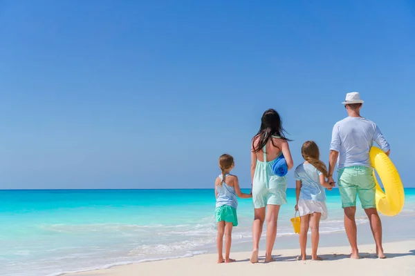 Dört tropik bir plajda mutlu güzel aile. Ebeveynler ve çocuklar arka plan deniz kıyısı — Stok fotoğraf