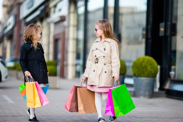 Kinder auf Einkaufstüten spazieren in der Stadt im Freien — Stockfoto