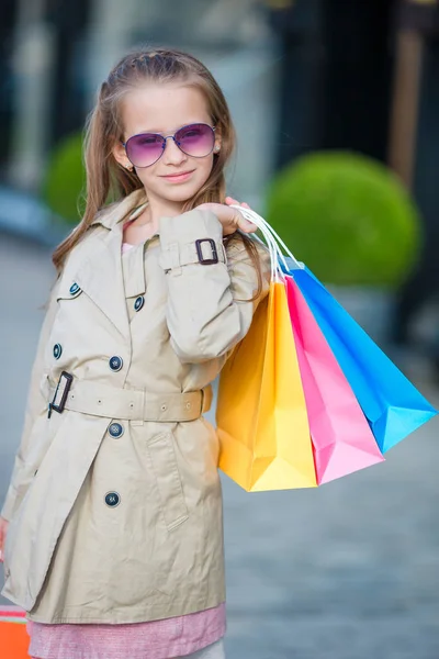 Alışveriş torbaları açık havada ile sevimli küçük kız portresi. Moda yürümeye başlayan çocuk Avrupa şehri açık havada — Stok fotoğraf